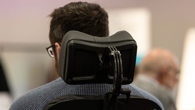 Photograph of the back of a man's head sitting in a power wheelchair