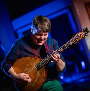 Marit playing a musical instrument called mandola.